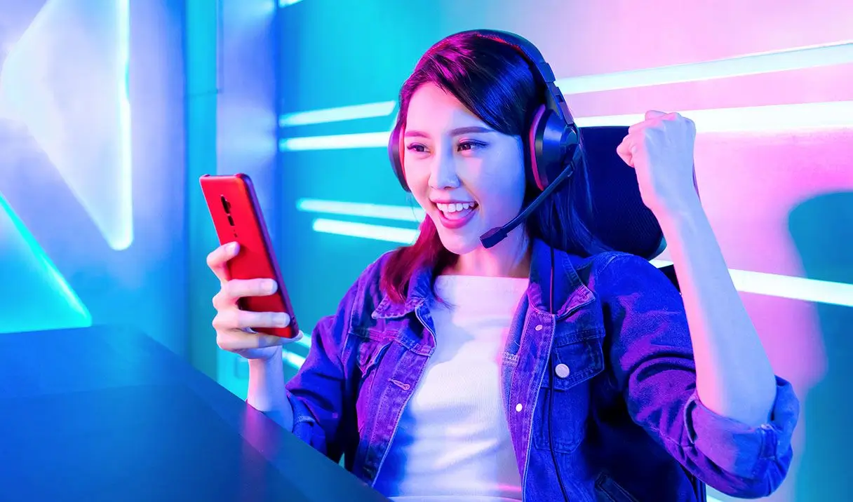 Mädchen mit Smartphone in der Hand beim Esports Gaming